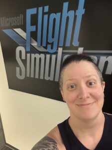 Hilary standing in front of the Microsoft Flight Simulator sign